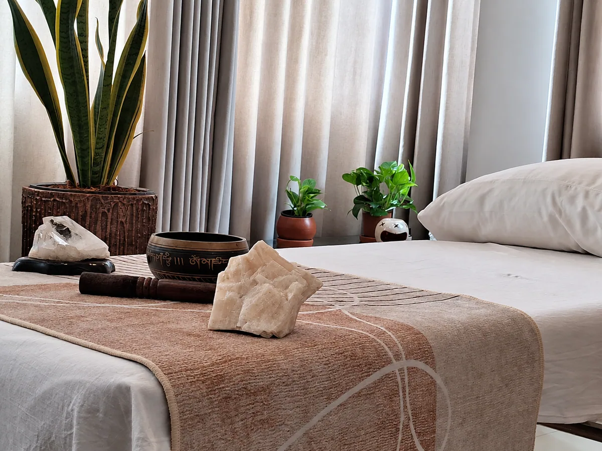 The REI studio, with a treatment bed, singing bowl, crystals and plants