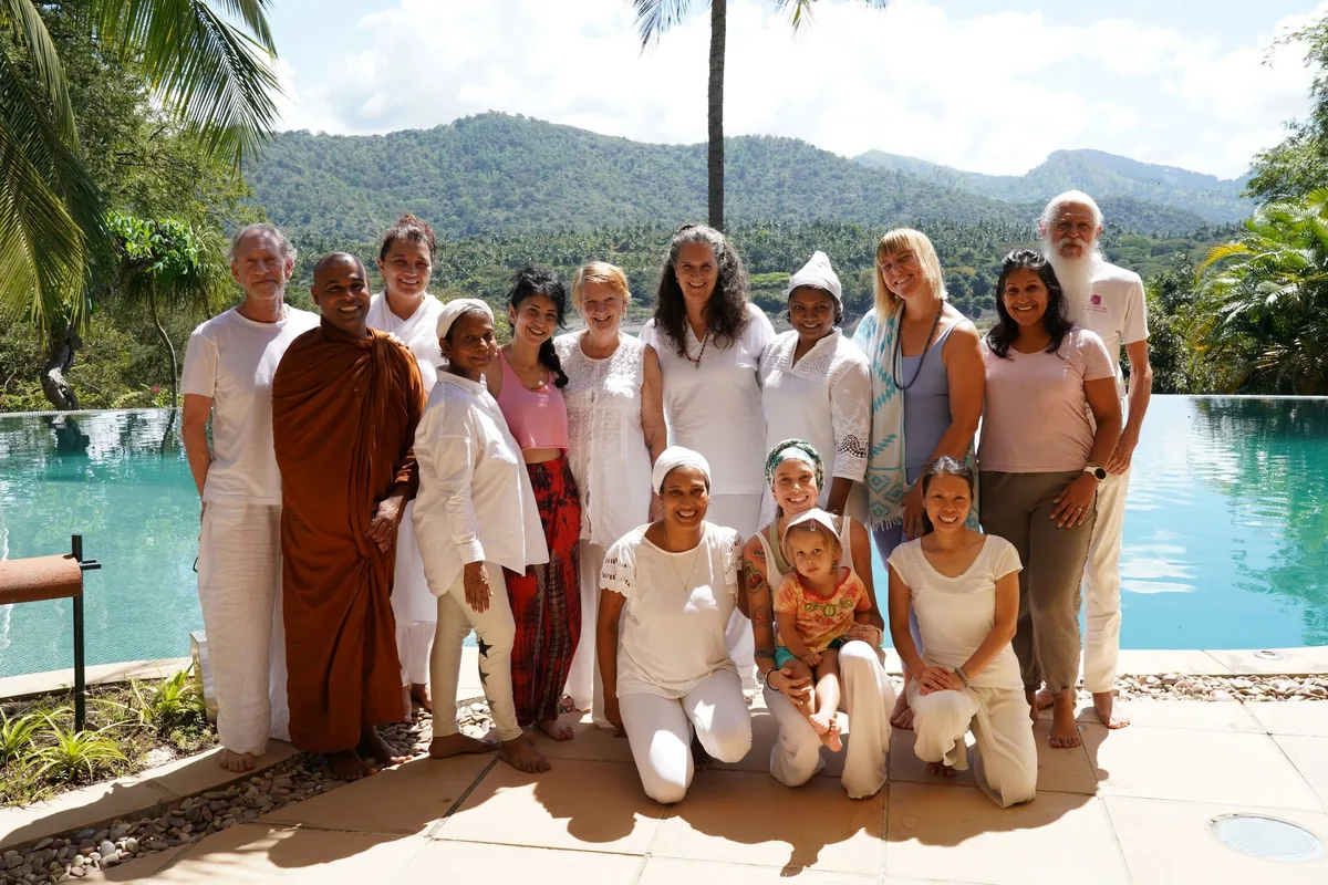 The Conscious Communication training group gathered beside a pool with hills behind them